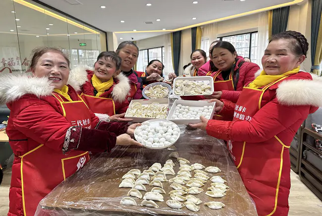 （图为：阿姨们展示包好的饺子、汤圆）.png