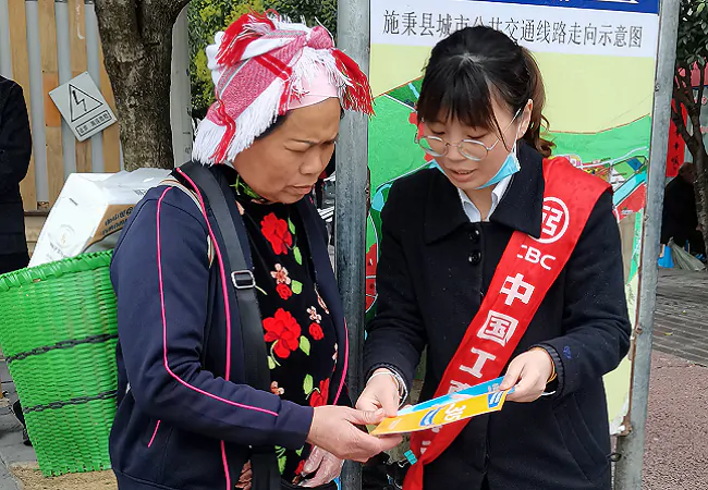 (图为:该行向行人发放宣传手册).png