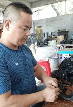 (图为:王瑞铖正在制作胶鞋).jpg