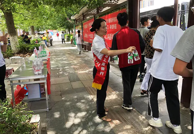 （图为：该行爱心助考志愿者为考生及家长免费提供饮用水）.png