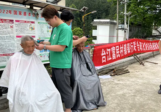 （图为：理发师为村民义务理发）.png