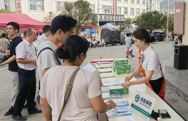 （图为：工作人员向群众宣讲金融知识）.png