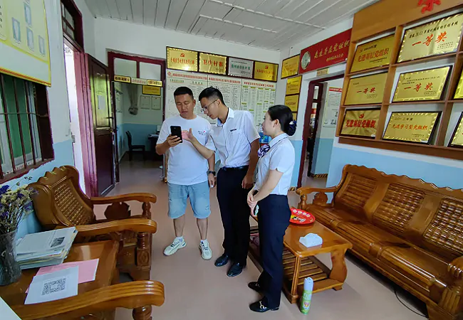 (图为:客户经理到村委开展宣传).png