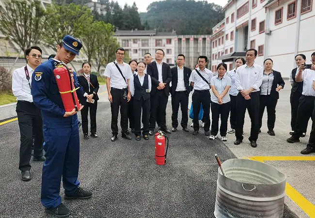 (图为:消防人员讲解灭火器使用方法并进行灭火演练).png