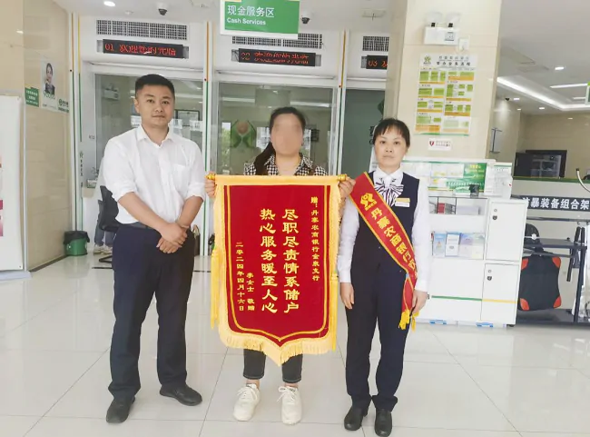 （图为：李女士将锦旗送到丹寨农商银行金泉支行）.png