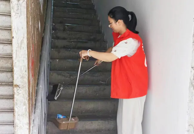 图为该行志愿者清扫社区居民楼楼道.jpg