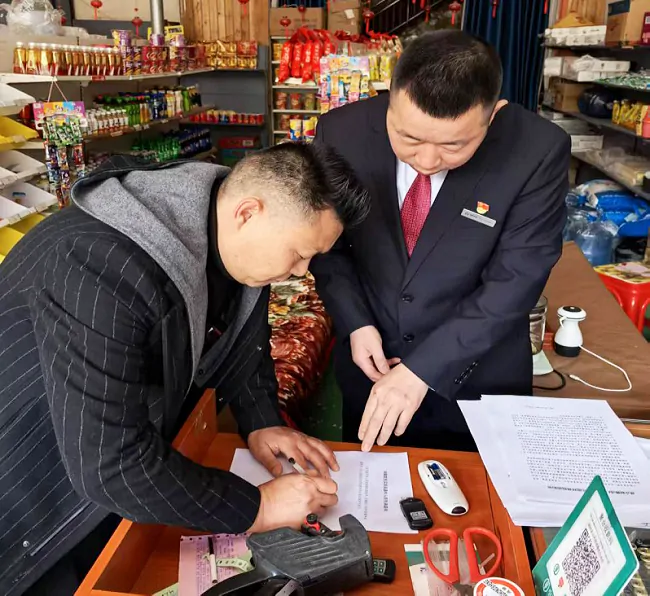 剑河农商银行工作人员引导商户签订承诺书.png