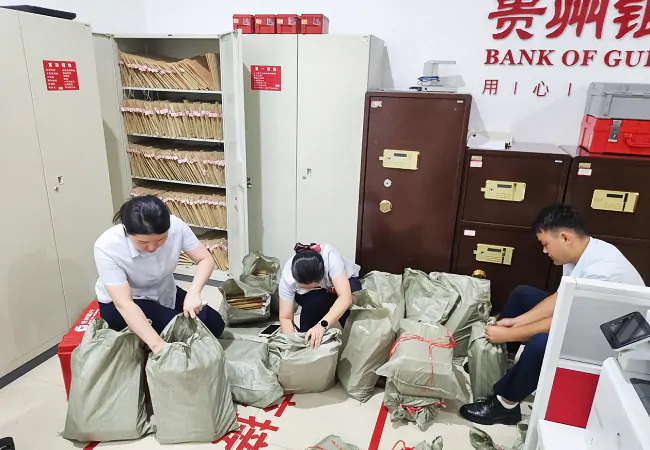 图为：贵州银行榕江支行员工正在打包档案紧急转移.png