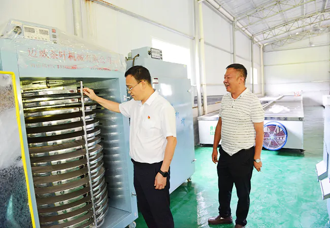 图为:剑河农商银行党委书记袁朝阳实地查看自动化加工车间.png