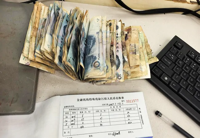 图为：为客户整理残缺污损人民币.png