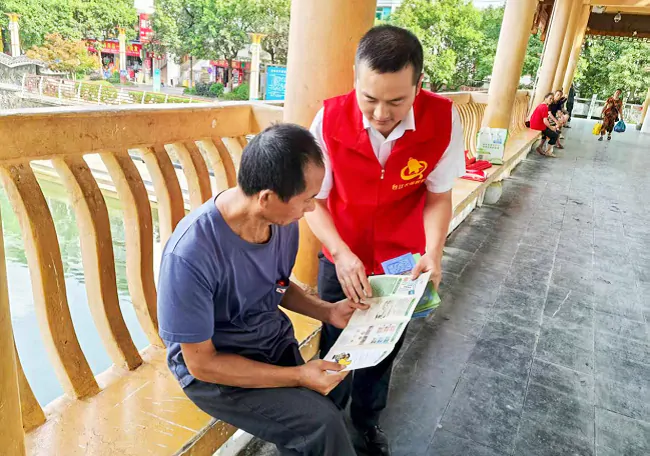 图为:工作人员向群众开展金融知识宣传.png