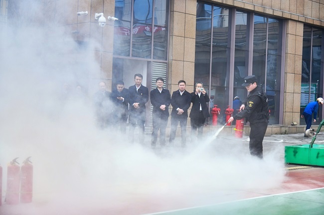 图为：消防员指导讲解后，银行保安实操灭火器.jpg